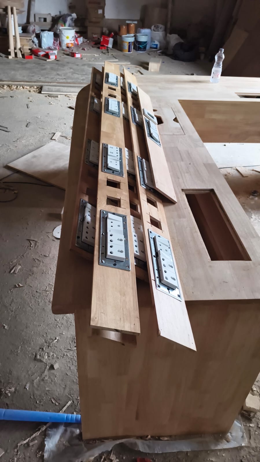 Site photograph, September 2025: a wooden desk being built on site, with rows of power sockets set into strips of timber laid along its top.